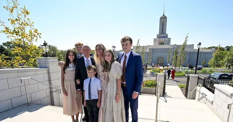 A happy family takes a picture in front of the temple.
