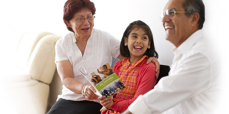 Smiling family members review their My Family Booklet.