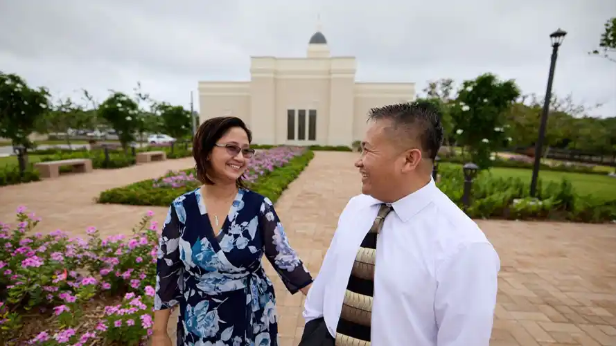 A happy couple walking on the temple grounds.