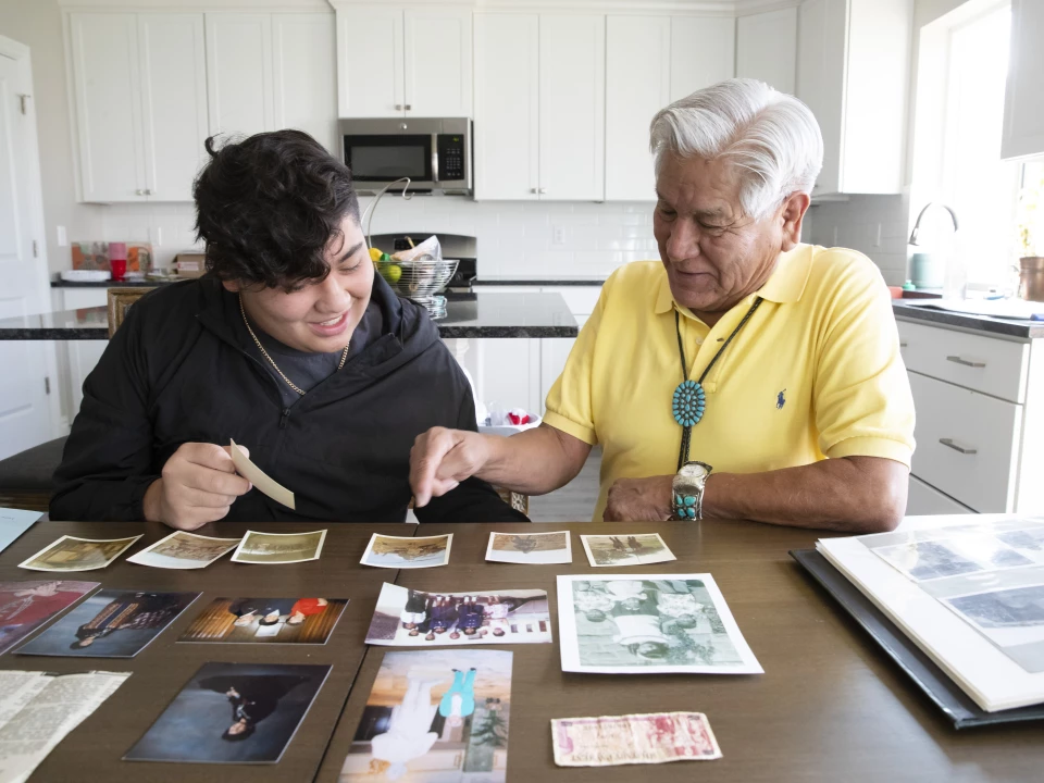 Grandfather and grandson looking at photos of their ancestors.