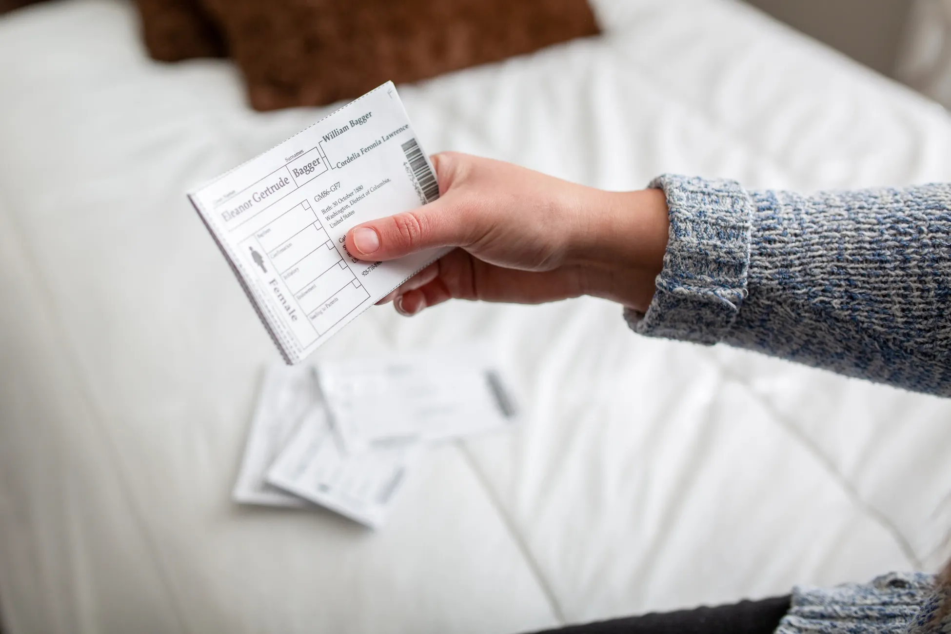 A person holds a few family name cards.